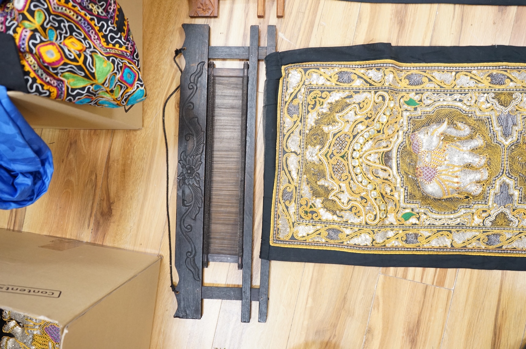 A quantity of mostly 20th century Middle Eastern and Indian woven and printed textiles and a peacock feather fan (2 boxes).